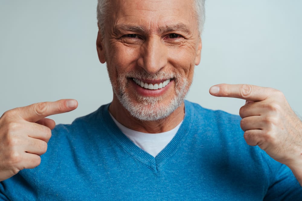 A smiling older man proudly shows off his healthy teeth, proof that quality dental care is ageless. - Dentist in South Gate, CA