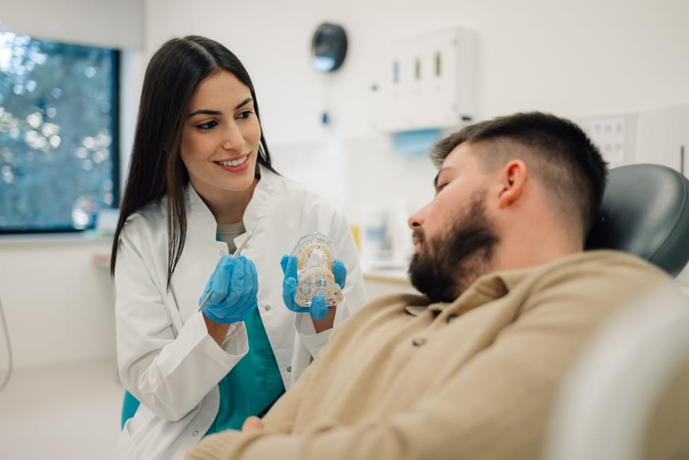 A young girl with braces smiles confidently while seated in a dental chair, showcasing a positive orthodontic visit even during unexpected dental concerns – Emergency Dentist in San Fernando, CA.