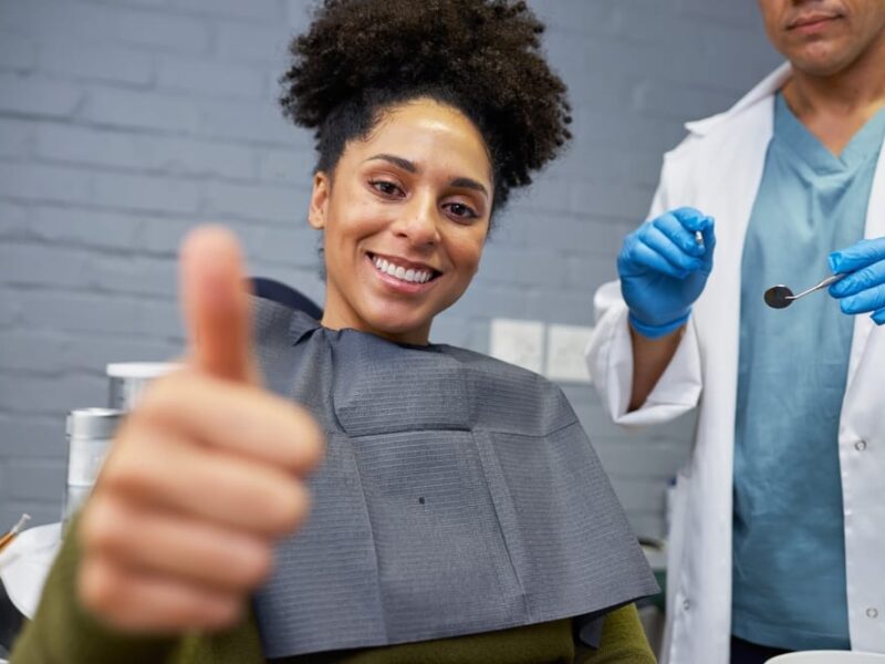 Smiling,Woman,Giving,Thumbs,Up,At,Dentist,Office,During,Checkup